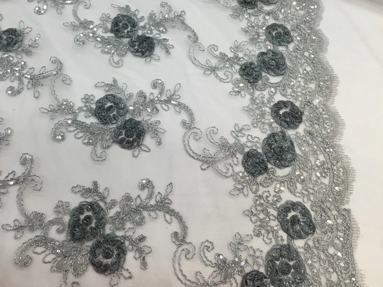 Gray/silver  3d flowers embroider with sequins on a mesh lace fabric. Sold by the yard.